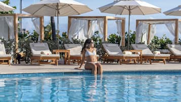 A poolside area with lounge chairs and umbrellas.