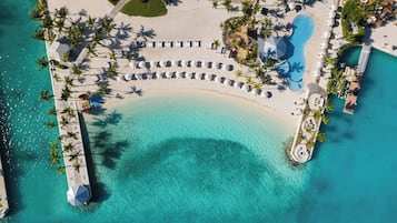 Privat strand, hvit sand, solsenger og parasoller