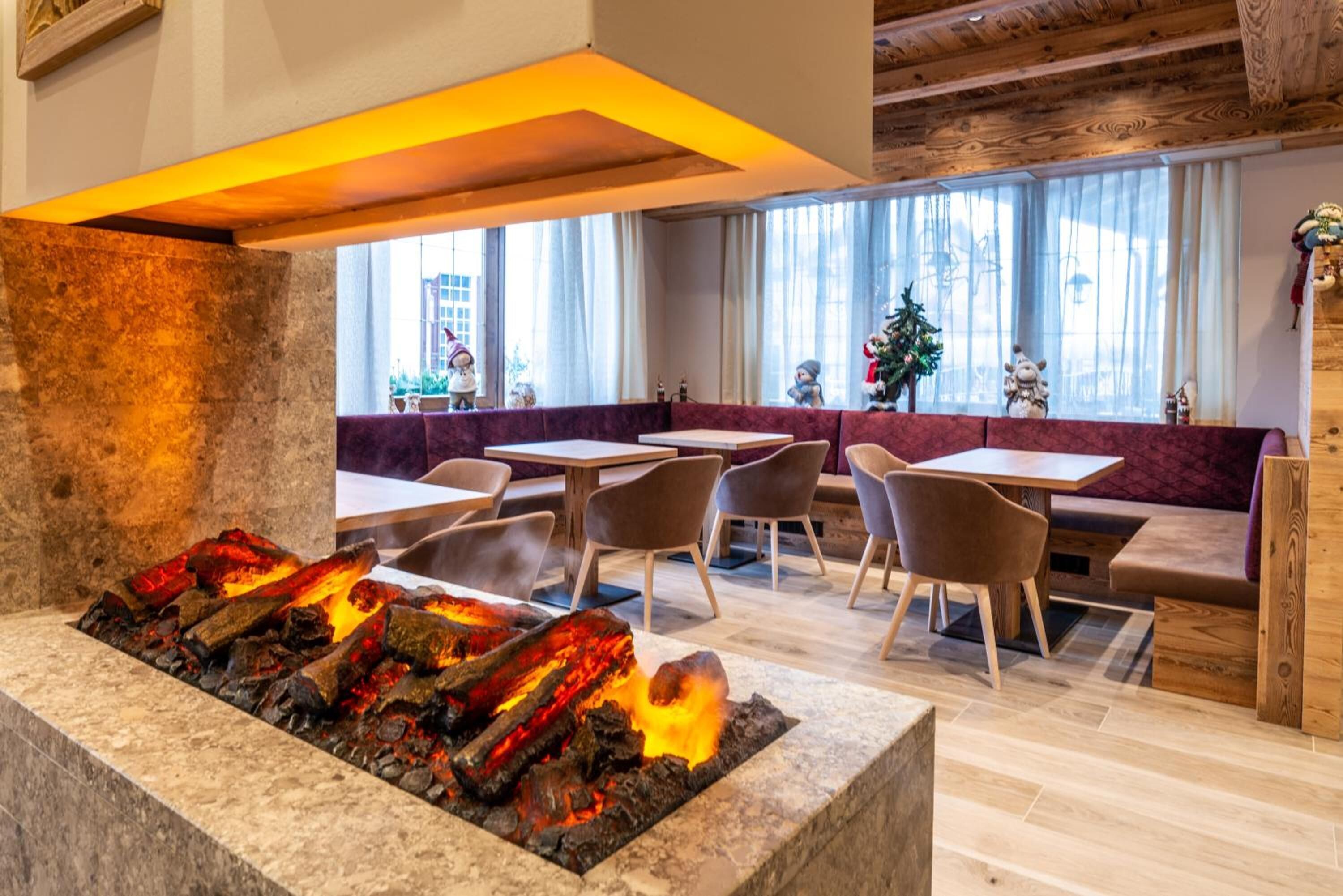 Un restaurante con una chimenea central, mesas y sillas de madera.