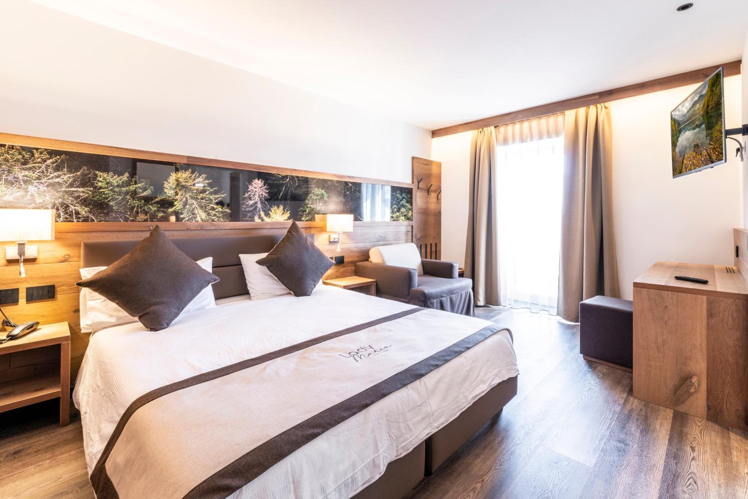 Een moderne hotelkamer met een groot bed, een bureau en een zithoek.