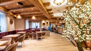 Een restaurant met houten balken, tafels en stoelen.