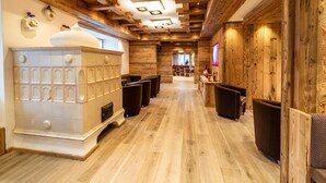 Een hotel lobby met een houten inrichting, een open haard en een televisiescherm.