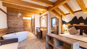 Een moderne badkamer met een vrijstaand bad, houten balken en een houten wand.