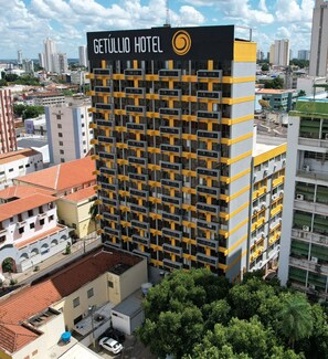 Een hoog hotelgebouw met een modern design, met een opvallend logo bovenaan.