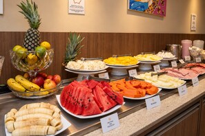 Een buffet met diverse soorten fruit en kazen.