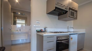 A modern kitchen with a built-in oven, microwave, and a stainless steel range hood.
