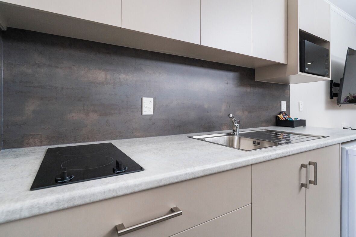 Una cocina moderna con encimera de granito, pileta de acero inoxidable y estufa integrada.