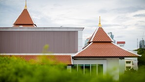 A building with traditional Thai architectural elements, including pointed roofs and a golden spire. - Aiyara Grand Hotel (Pattaya)