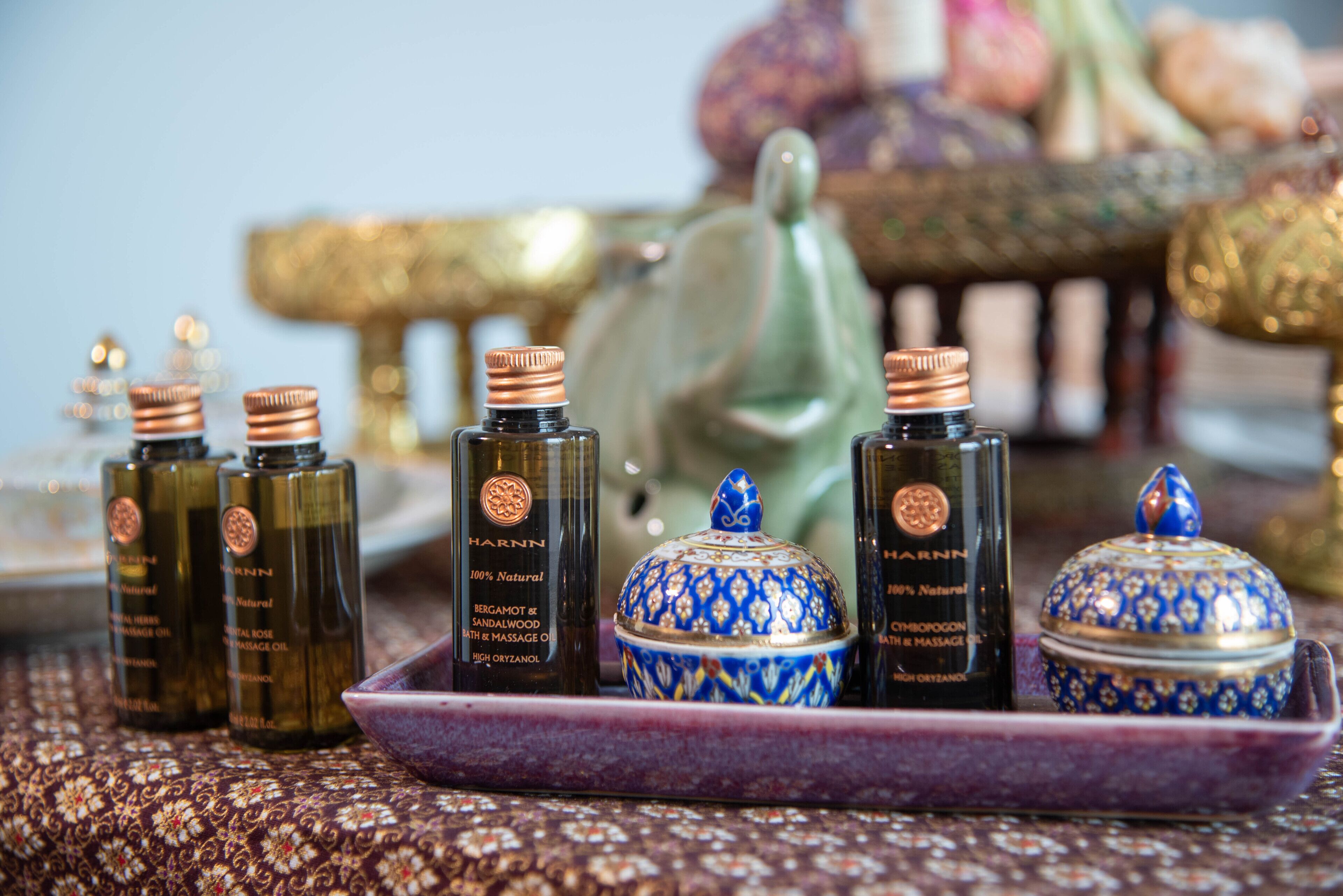 A tray with bottles of massage oil and a decorative blue and gold container.