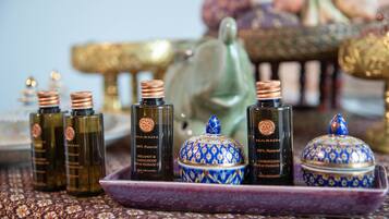 A tray with bottles of massage oil and a decorative blue and gold container.