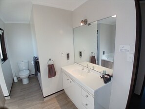 A modern bathroom with a white sink, mirror, and toilet. - Palm City Motor Inn (Napier)
