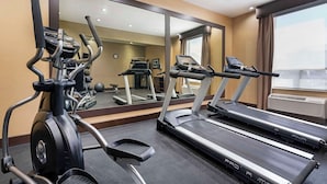 A gym with treadmills, an elliptical, and a mirrored wall. - Best Western Pacific Inn (Vernon)
