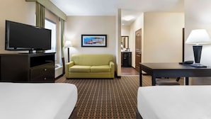 A hotel room with a bed, a TV, a sofa, a desk, and a lamp. - Best Western Pacific Inn (Vernon)