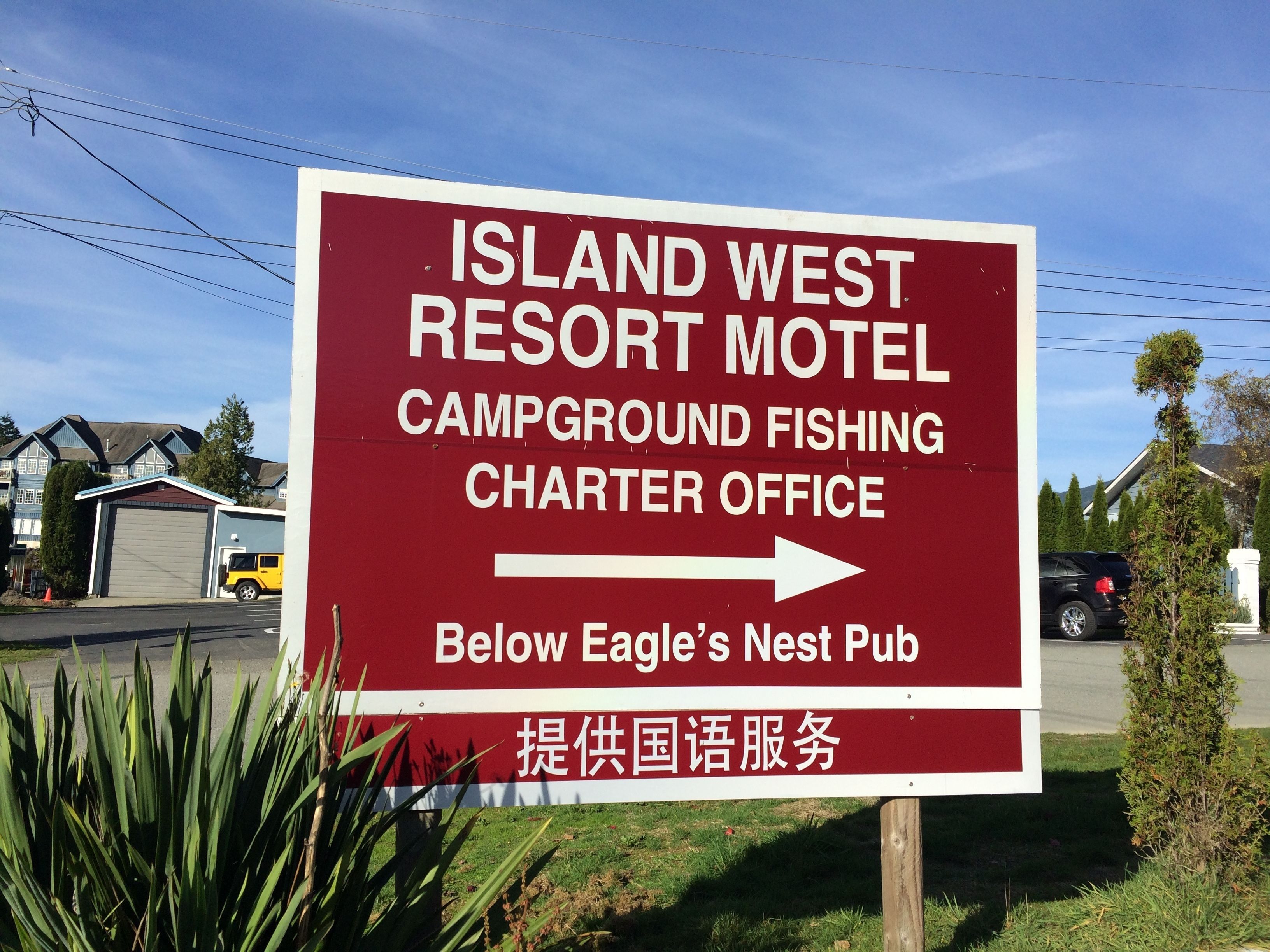 A sign for Island West Resort Motel, indicating a campground fishing charter office and Eagle's Nest Pub below.