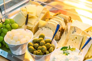 Una presentación de quesos y aceitunas, con diferentes tipos de queso y aceitunas en cuencos.