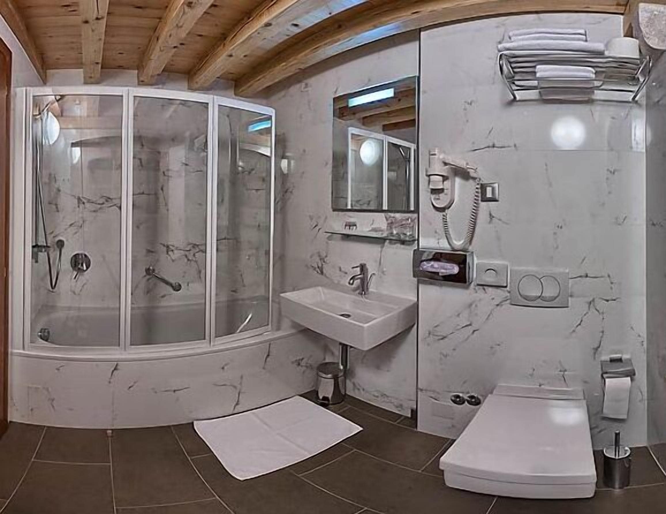Une salle de bain avec une douche à parois de verre, un lavabo et des toilettes.