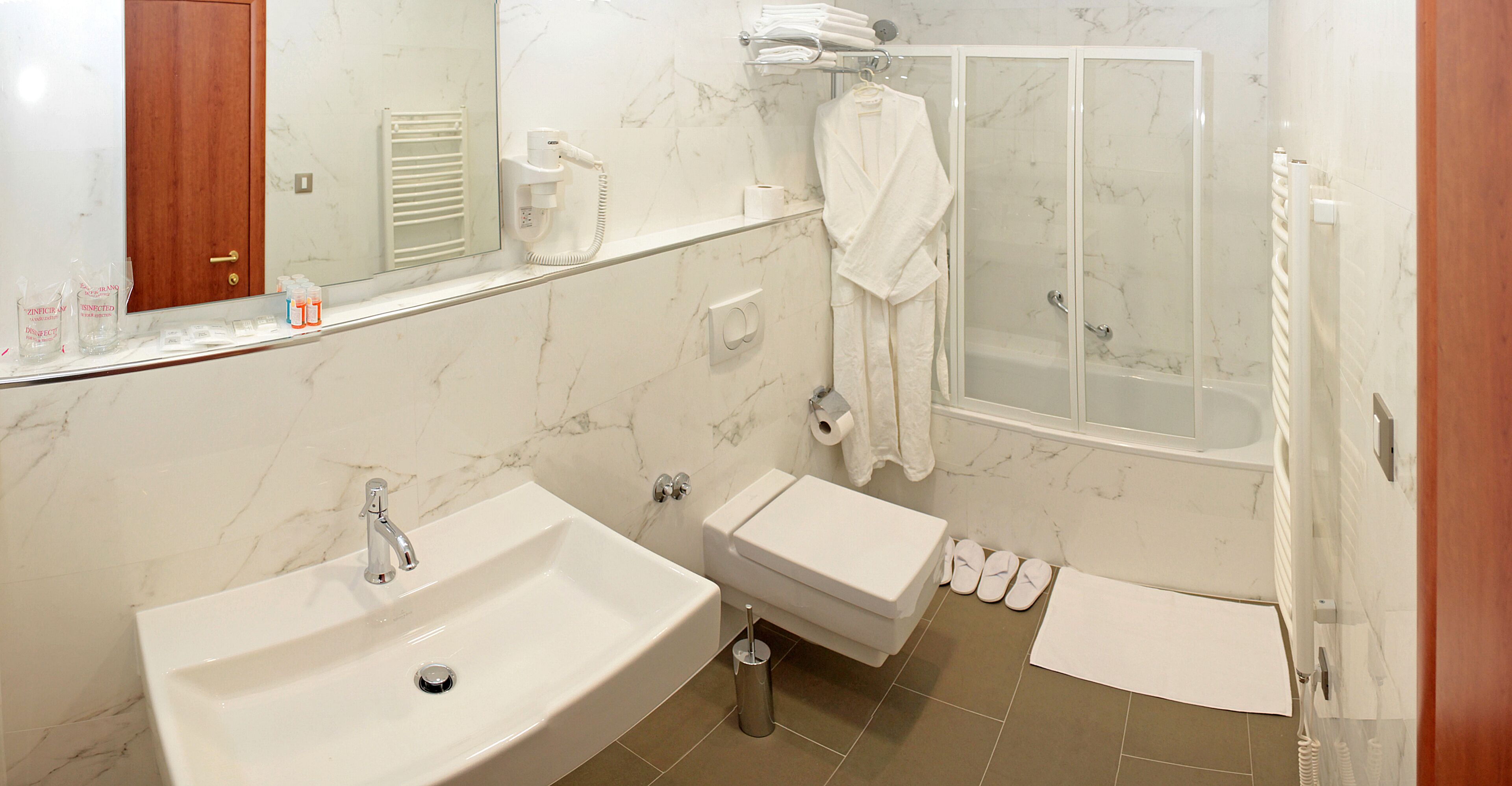 A bathroom with a sink, toilet, and shower.