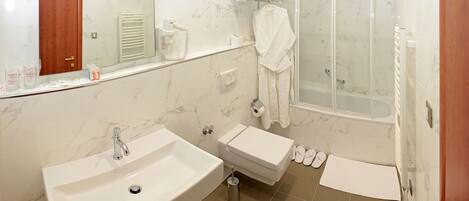 A bathroom with a sink, toilet, and shower.