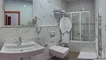 A modern bathroom with two sinks, a shower, and a glass-enclosed shower area.