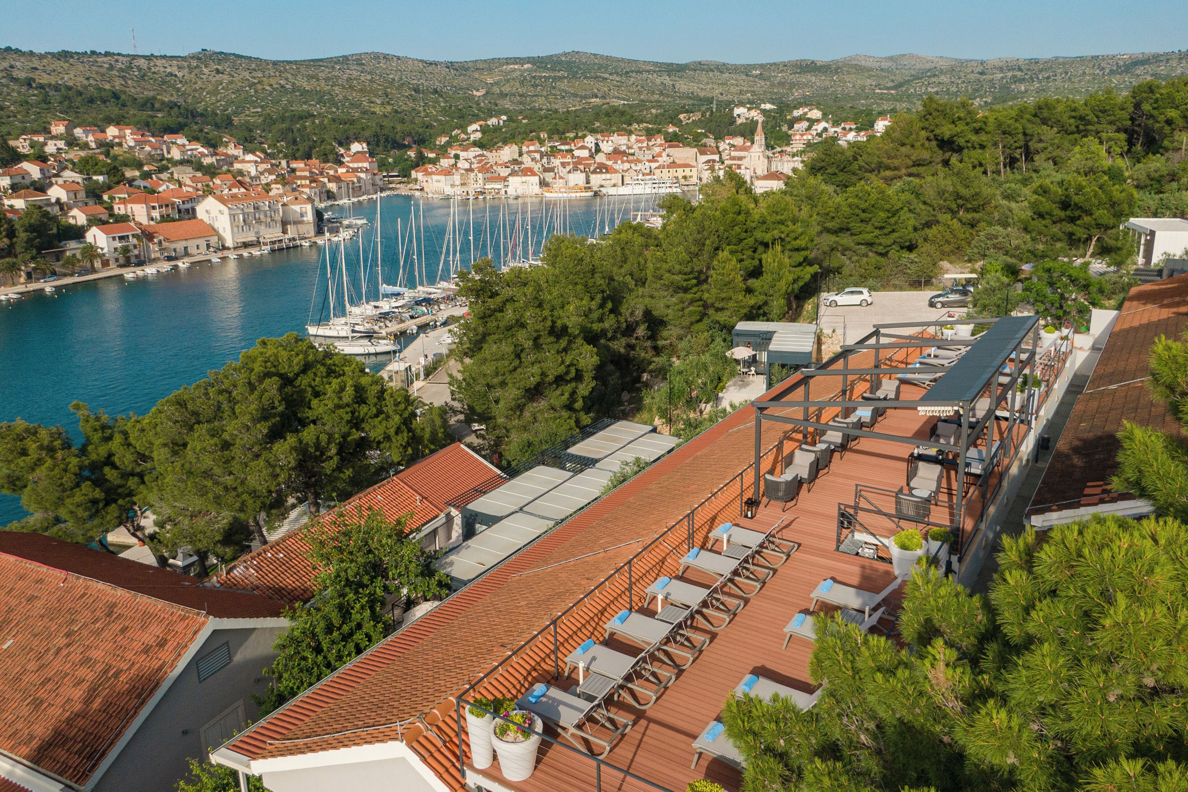 A coastal town with a marina, terraced rooftops, and lush greenery.