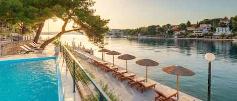 Piscine extérieure, parasols de plage, chaises longues