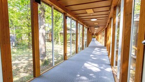 A corridor with wooden beams, large windows, and a carpeted floor. -  Marwell Hotel Winchester South (Winchester)