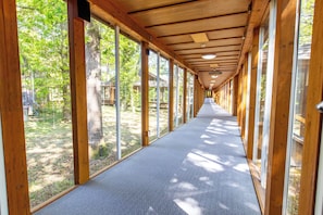 A corridor with wooden beams, large windows, and a carpeted floor. -  Marwell Hotel Winchester South (Winchester)
