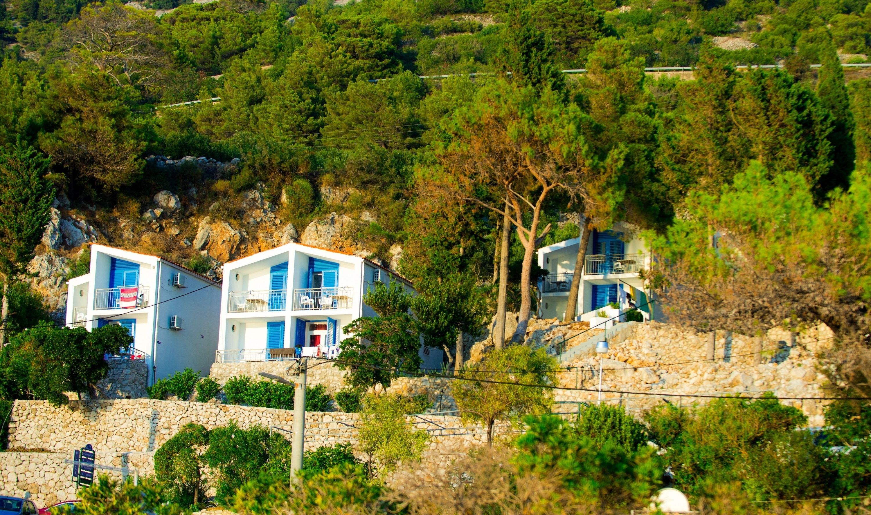 Un bâtiment situé sur la côte, doté d’un mur en pierre et d’un balcon.