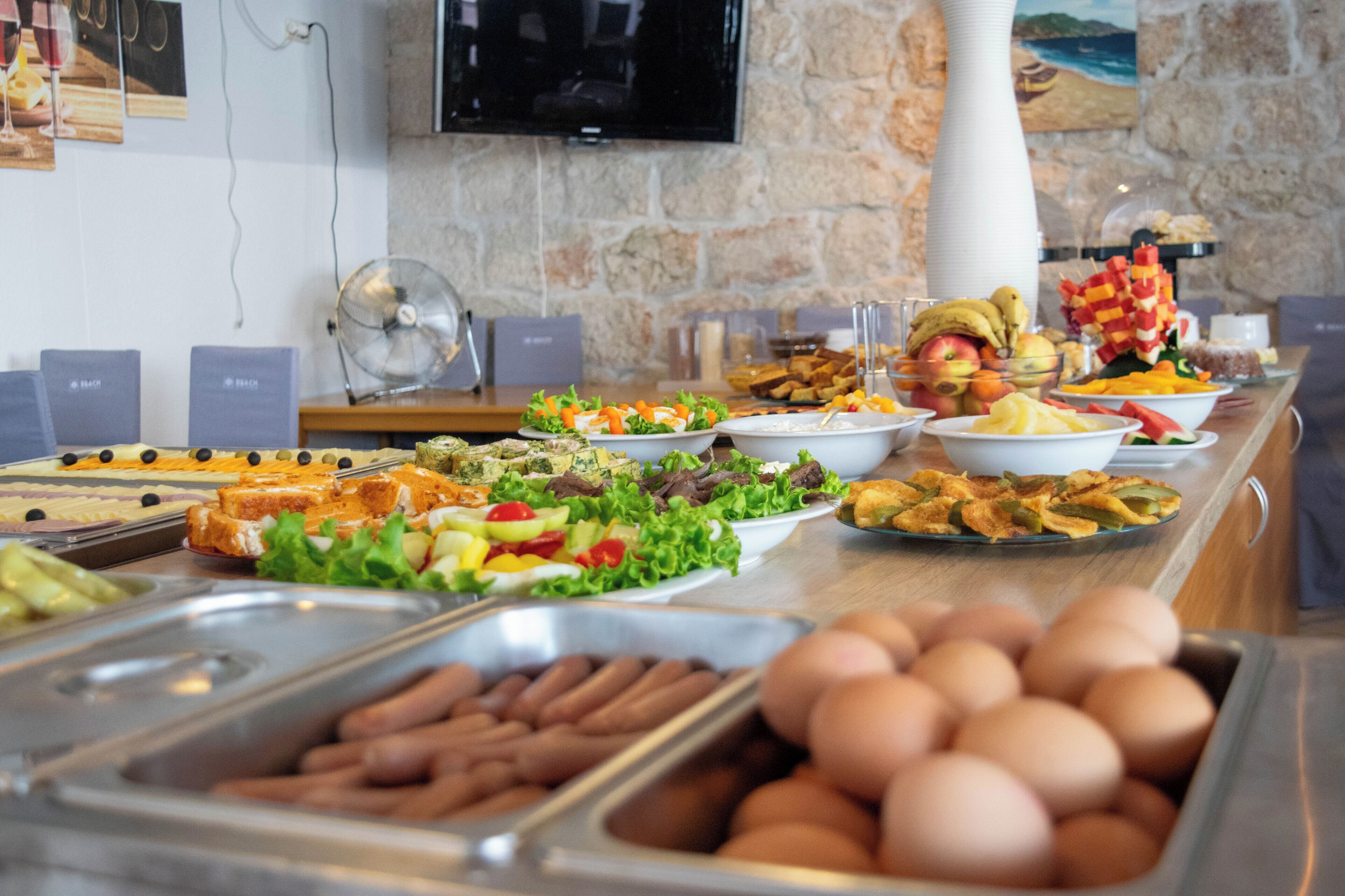 A buffet with various food items including eggs, salads, and bread.
