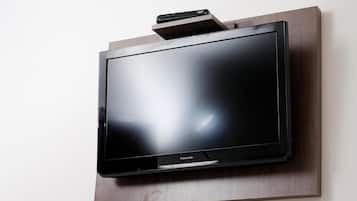 Litteä näyttöinen televisio on kiinnitetty puiseen seinään.