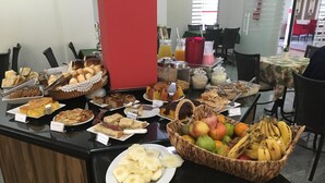 A buffet with various food items including fruits, pastries, and desserts. - Hotel Dois H (Joinville)
