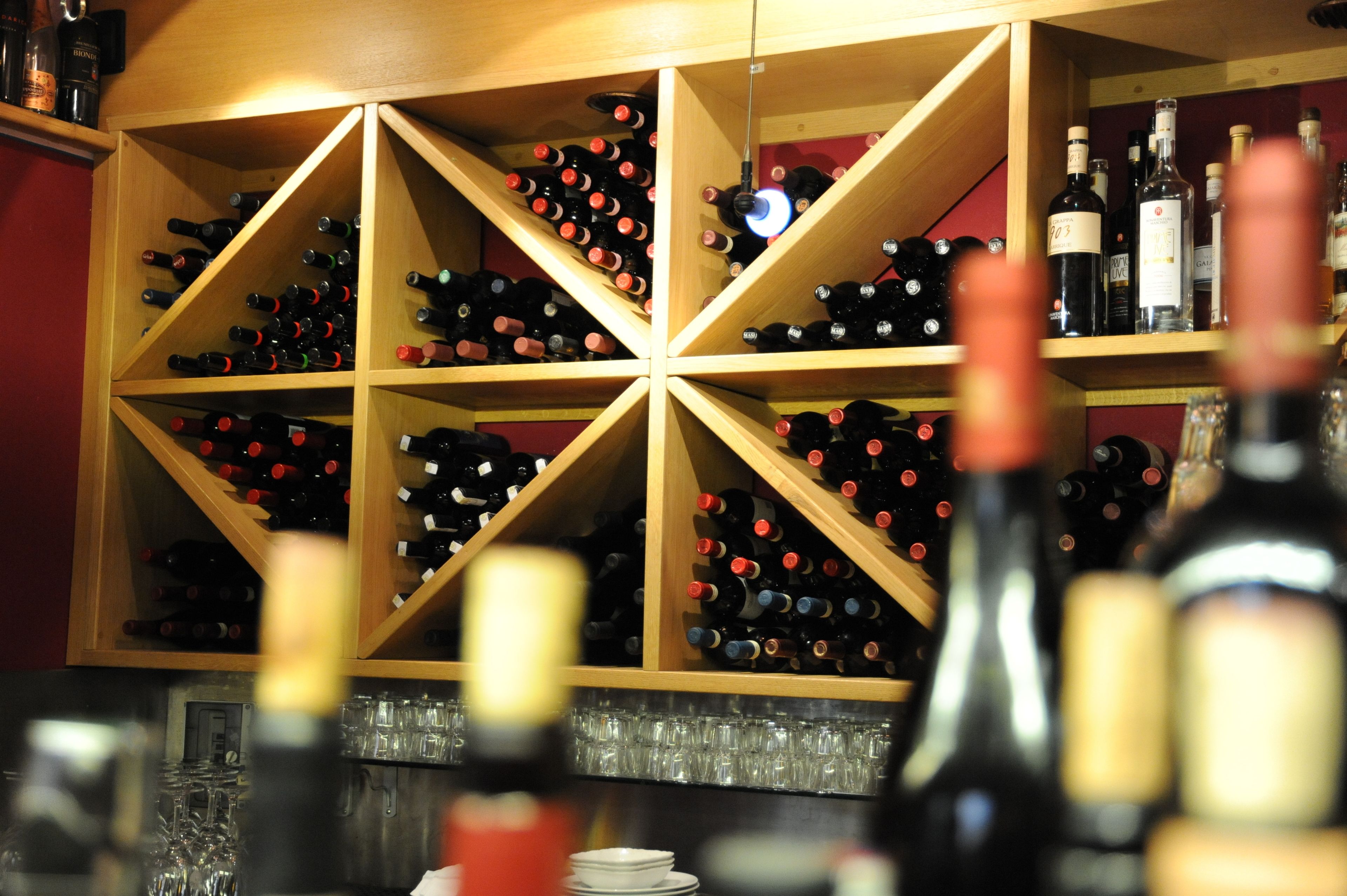 A wine cellar with multiple wooden shelves filled with wine bottles.