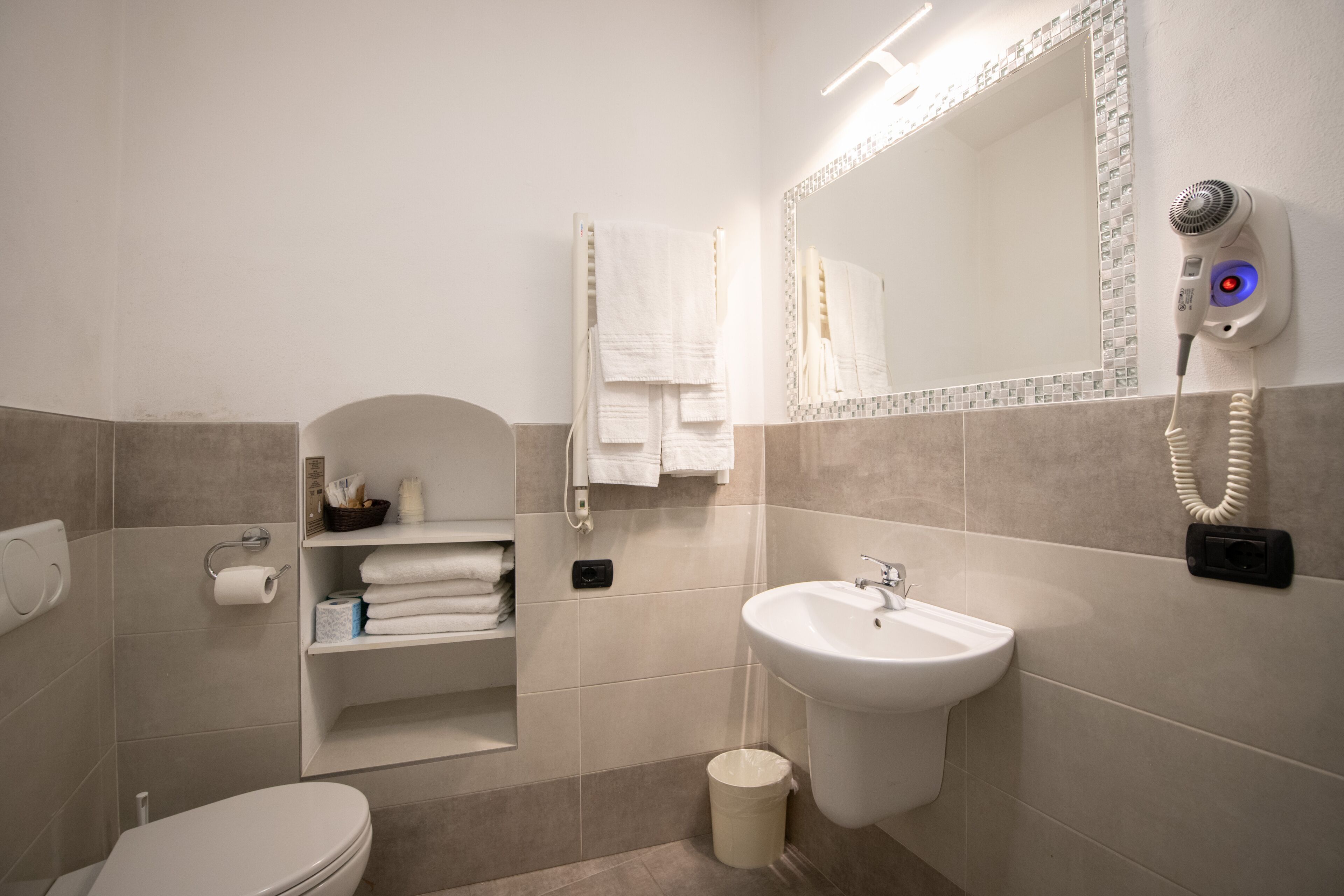 Un bagno moderno con il water, un lavandino e un portasciugamani.