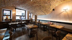 Un restaurant avec un plafond en briques, des tables et des chaises en bois.