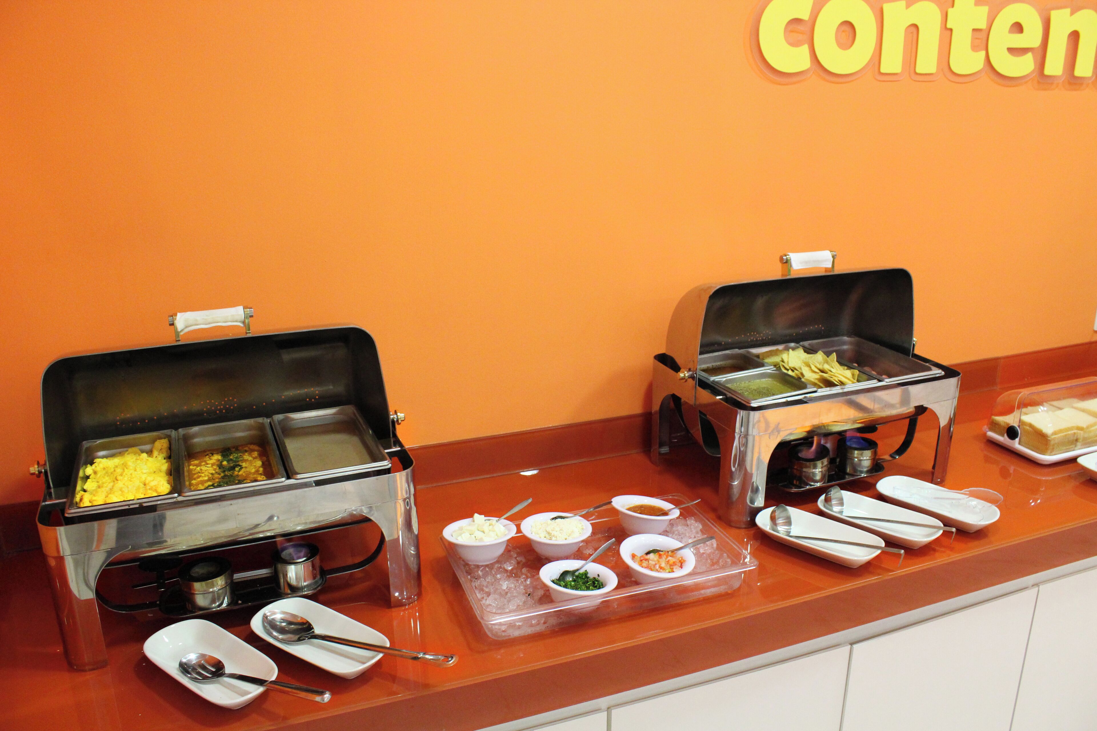 Un buffet proposant une variété de plats et d’ustensiles de service.