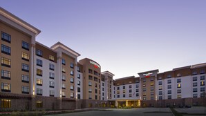 A Courtyard by Marriott hotel with multiple buildings, a central entrance, and a parking area. - Courtyard by Marriott Dallas DFW Airport North/Grapevine (Grapevine)