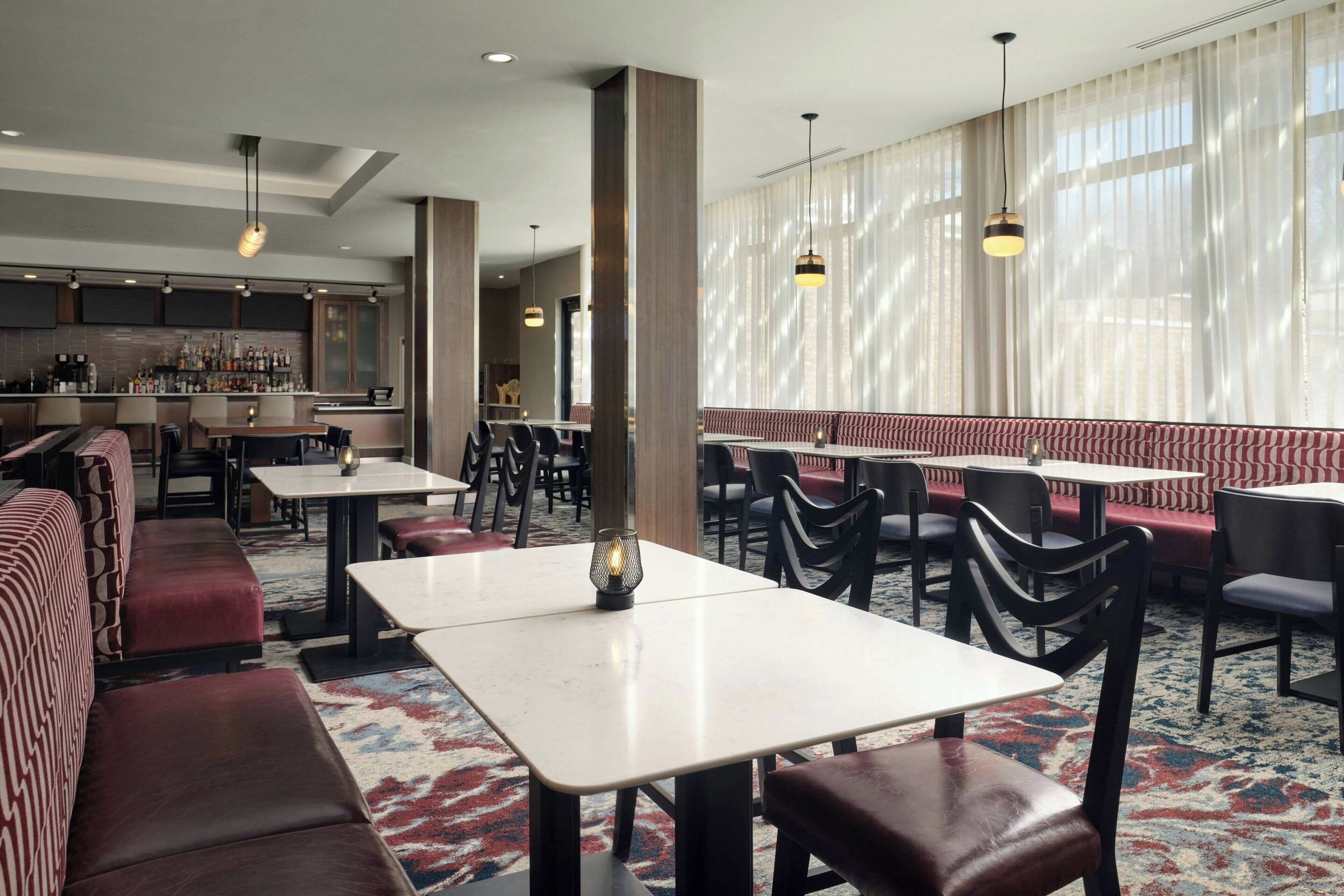 Un restaurante con cabinas, mesas y una zona de bar.