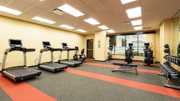 Et fitnesscenter med løbebånd, crosstrainere og vægtbænke.