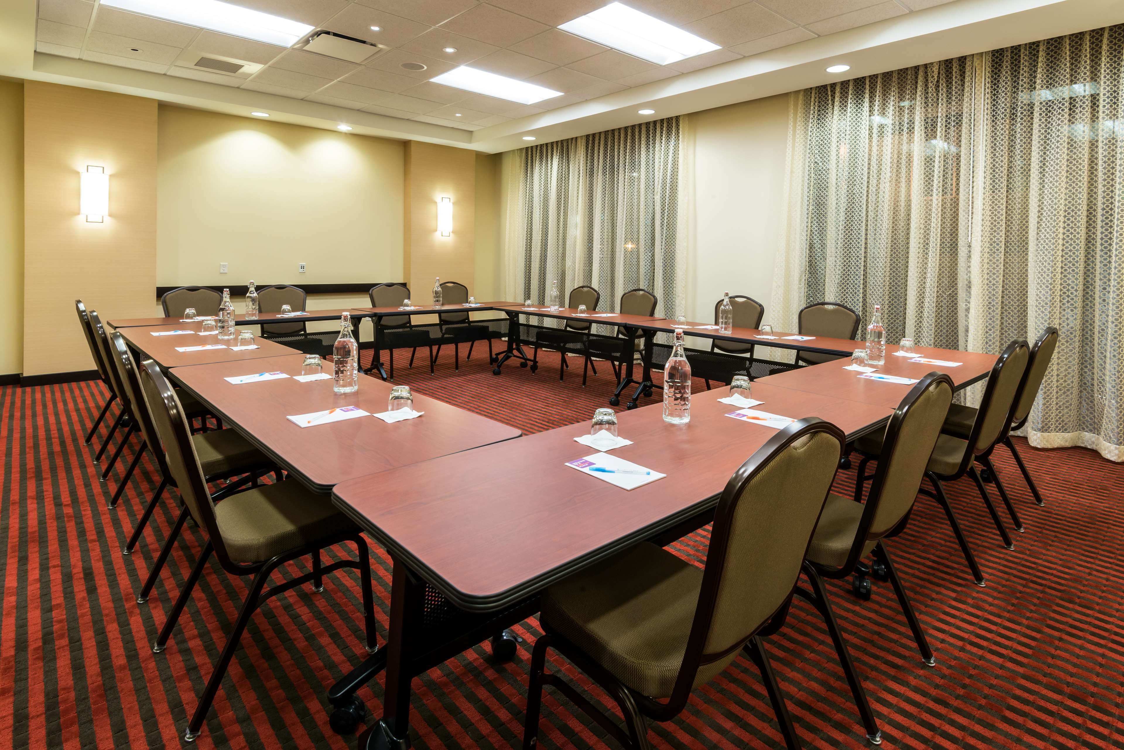 A conference room with a long table, chairs, and water bottles.