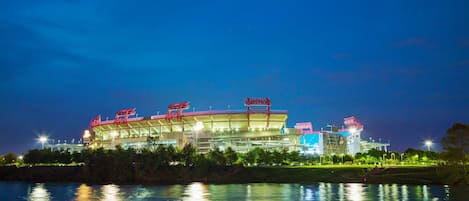 A stadium with a large open field and a body of water in the foreground.