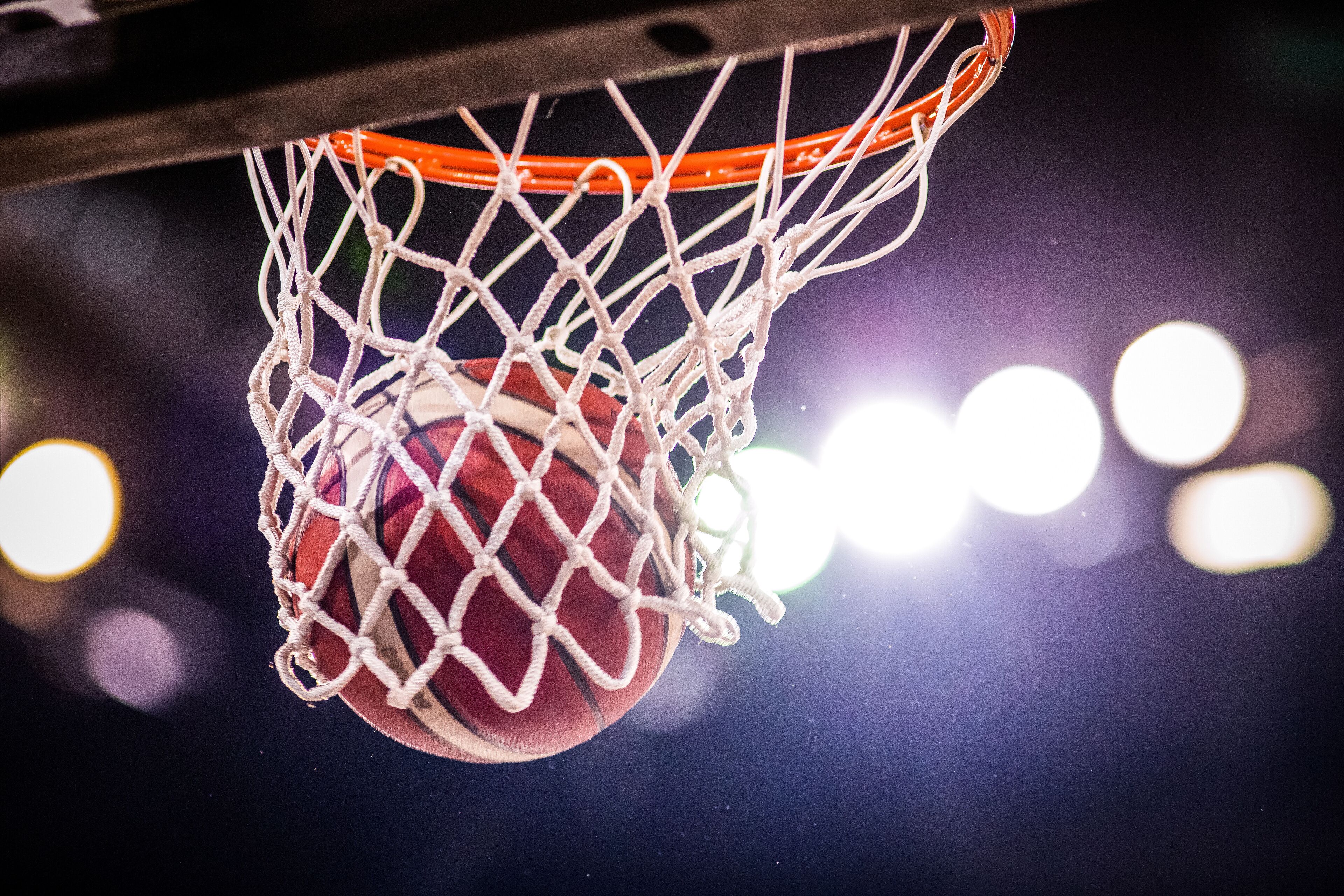 A basketball hoop with a net and a basketball.