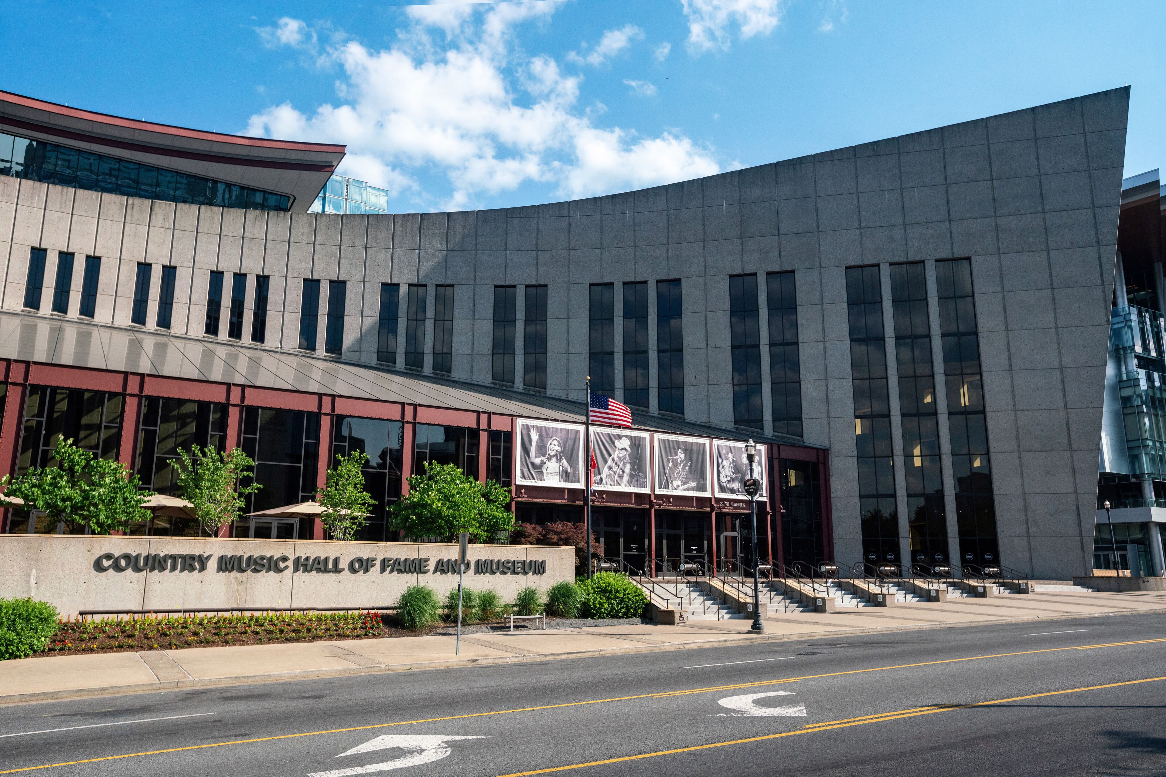 Un edificio moderno con fachada curva, ventanas grandes y un cartel que dice "Country Music Hall of Fame and Museum".