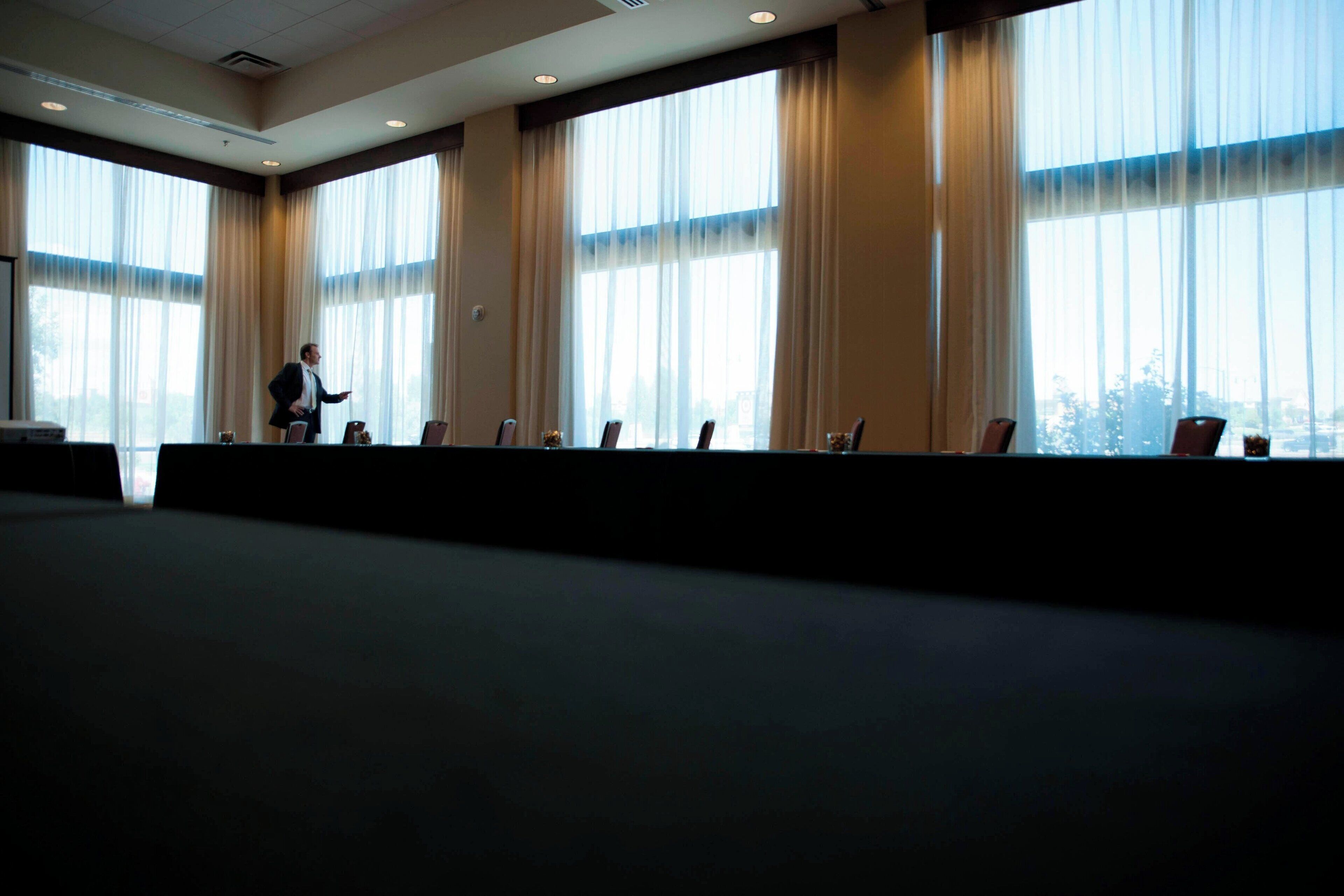 Une salle de conférence dotée de grandes fenêtres, d’une longue table et de chaises.