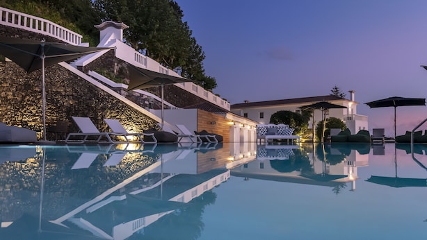 A pool area with lounge chairs and a staircase leading to a building. - Quinta da Abelheira (Ponta Delgada)
