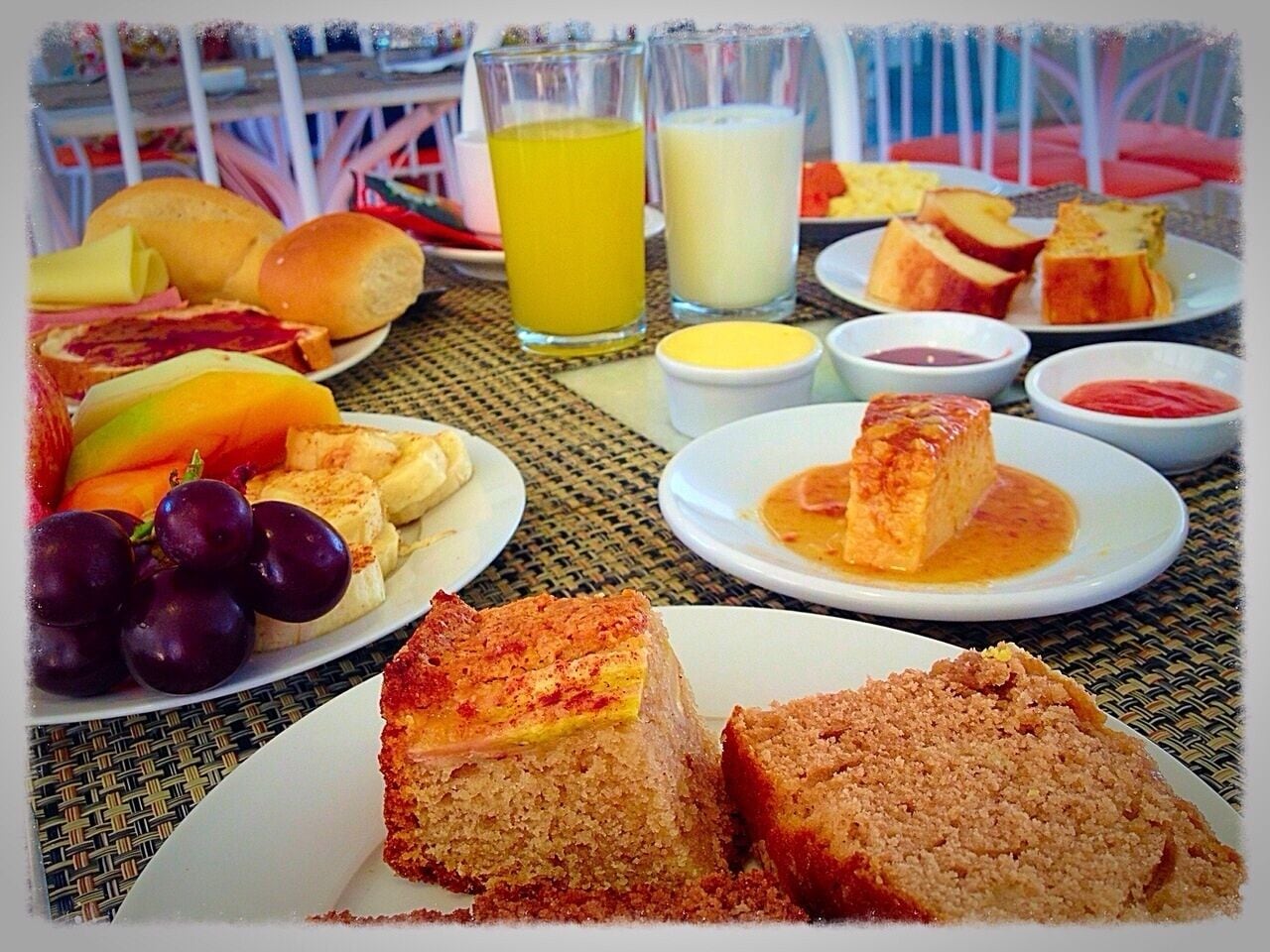 Una mesa con diversos alimentos, como pan, queso, frutas y bebidas.
