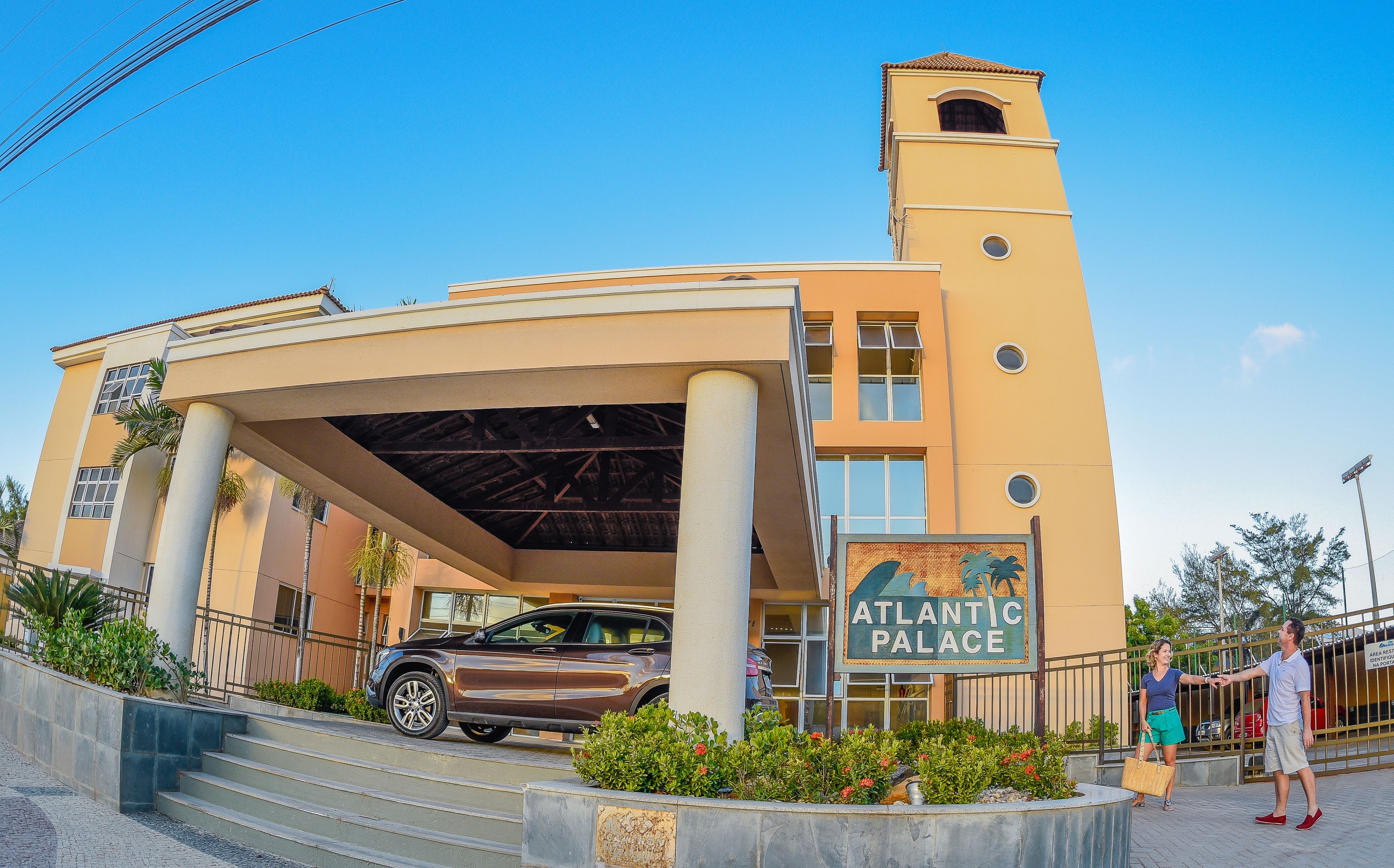 A building with a sign reading "ATLANTIC PALACE" and a parked SUV.