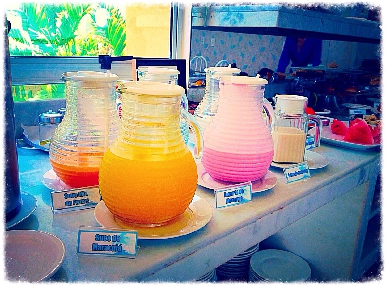 A beverage station with labeled pitchers of fruit juices.