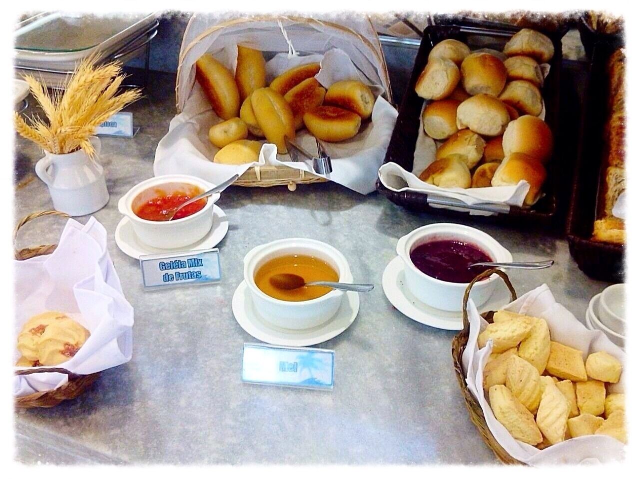 Une table de buffet proposant divers plats, notamment des petits pains, de la soupe et des sauces.