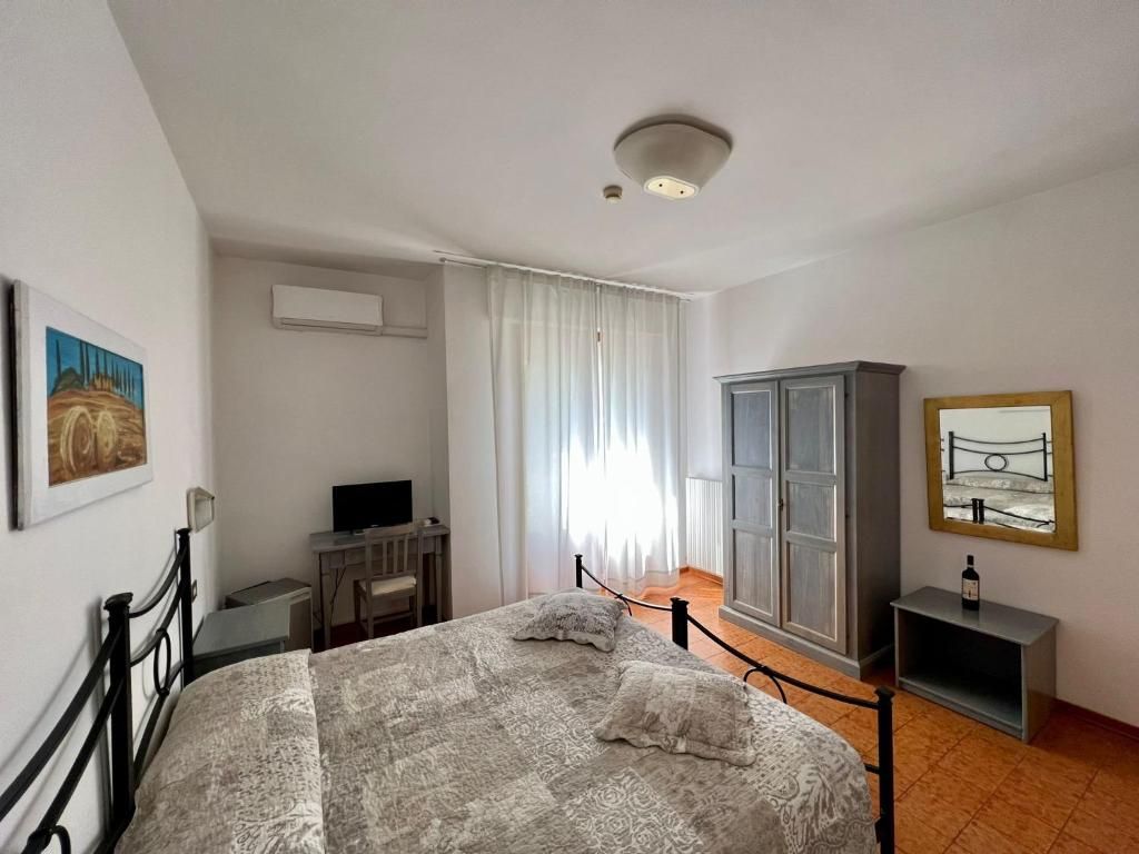 Una camera da letto con un letto, una scrivania, una televisione e un armadio.