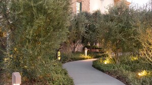A building with a large arched entrance, a tower with a dome, and a pathway leading to the entrance. - Ponte Vineyard Inn (Temecula)
